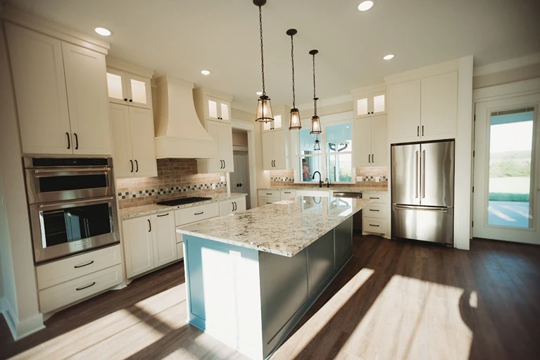 Modern kitchen with backsplash and stone island. 